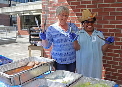Photo of two staff members serving up the food.